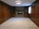 Cozy living room with carpet, paneled walls, fireplace, and built-in bookshelves for storage and decor at 2104 Moon Sw Dr, Conyers, GA 30094