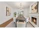 Elegant dining room featuring a fireplace, chandelier, hardwood floors, and modern art at 235 The Prado N, Atlanta, GA 30309