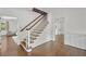 Bright entryway featuring hardwood floors, elegant staircase, and doorways leading to other rooms at 235 The Prado N, Atlanta, GA 30309