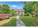 Traditional home with manicured lawn, mature landscaping, and stone walkway leading to the front door at 235 The Prado N, Atlanta, GA 30309