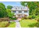 Charming two-story white home featuring manicured lawn and a welcoming stone walkway at 235 The Prado N, Atlanta, GA 30309