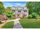 Traditional home showcasing dormer windows, shutters, landscaped yard, and stone walkway at 235 The Prado N, Atlanta, GA 30309