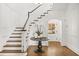 Elegant foyer with hardwood floors, paneled walls, staircase, and decorative table at 235 The Prado N, Atlanta, GA 30309