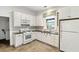 Well-lit kitchen with white cabinets, appliances, dark countertops and decorative window treatments at 235 The Prado N, Atlanta, GA 30309