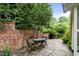 Outdoor patio with stone pavers, brick wall, wooden table and grill at 235 The Prado N, Atlanta, GA 30309
