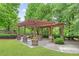 Community pergola featuring wooden beams and stone support bases, surrounded by trees and shrubbery at 3901 Old Atlanta Station Se Dr, Atlanta, GA 30339