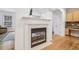 View of the fireplace in a living space with wood floors, decorative columns, and kitchen area at 3901 Old Atlanta Station Se Dr, Atlanta, GA 30339