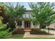 Two-story home with a covered front porch, manicured landscaping, and mature trees at 453 Carter Se Ave, Atlanta, GA 30317