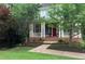 Charming two-story home featuring mature landscaping, a welcoming front porch, and a brick pathway at 453 Carter Se Ave, Atlanta, GA 30317