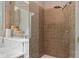 Close up of a tiled shower with a shower head, a glass door, and a built-in shelf at 453 Carter Se Ave, Atlanta, GA 30317