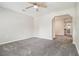 A spacious bedroom featuring soft gray carpet, neutral walls, and a modern ceiling fan at 211 Margaret St, Fairburn, GA 30213