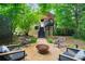 Lush backyard featuring a fire pit, seating area, gravel, landscaping, and stairs to the back entrance at 486 Haas Se Ave, Atlanta, GA 30316