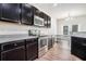 Modern kitchen featuring dark cabinets, stainless steel appliances, and granite countertops at 85 Brushed Ives Ct, Lawrenceville, GA 30045