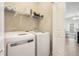 Convenient laundry area with modern, front-load washer and dryer and storage shelving at 85 Brushed Ives Ct, Lawrenceville, GA 30045
