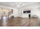 Bright open-plan living room featuring hardwood floors, a staircase, and opens into dining and kitchen at 85 Brushed Ives Ct, Lawrenceville, GA 30045
