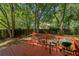 Back deck with wood flooring and a grill and seating, surrounded by large trees and a yard at 901 Winfield Se Ave, Atlanta, GA 30316