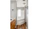Bathroom featuring a tub with tiled walls, wooden floors, and a window with a decorative frosted pattern at 901 Winfield Se Ave, Atlanta, GA 30316