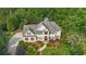 Overhead view shows the home's roof, driveway, landscaping, and surrounding trees and greenery at 104 Hidden Springs Ln, Peachtree City, GA 30269