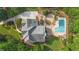 Drone shot displays house, in-ground pool, driveway, and verdant landscaping in a tree-filled setting at 104 Hidden Springs Ln, Peachtree City, GA 30269