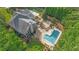 Stunning aerial view of estate home with a private pool, a beautiful deck, and lush, mature landscaping at 104 Hidden Springs Ln, Peachtree City, GA 30269