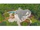 Aerial view capturing the home's layout, inviting pool, patio, three-car garage and lush, manicured yard at 104 Hidden Springs Ln, Peachtree City, GA 30269