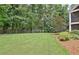 Lush backyard with mature trees and green lawn, providing ample space for outdoor activities and recreation at 104 Hidden Springs Ln, Peachtree City, GA 30269
