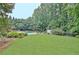 Expansive backyard with lush green lawn, mature trees, and a sparkling pool, offering a private outdoor oasis at 104 Hidden Springs Ln, Peachtree City, GA 30269