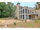 Spacious backyard boasts a large stone patio, screened porch, and mature trees, creating a private outdoor retreat at 104 Hidden Springs Ln, Peachtree City, GA 30269
