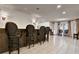 Finished basement wet bar with bar-height seating, tile floors, and elegant light fixtures at 104 Hidden Springs Ln, Peachtree City, GA 30269