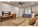 Cozy bedroom featuring hardwood floors, a ceiling fan, and a comfortable seating area with a TV at 104 Hidden Springs Ln, Peachtree City, GA 30269
