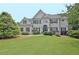 Stately two-story home featuring a lush green lawn and manicured landscaping at 104 Hidden Springs Ln, Peachtree City, GA 30269