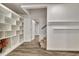 Finished basement hallway with white shelving, wood-look floors, white trim and carpeted stairs at 104 Hidden Springs Ln, Peachtree City, GA 30269