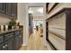 Hallway with access to a kitchen featuring dark cabinets and granite countertops at 104 Hidden Springs Ln, Peachtree City, GA 30269