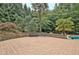 Backyard patio with stone seating, a pool view, and mature landscaping at 104 Hidden Springs Ln, Peachtree City, GA 30269