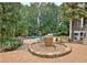 Beautiful backyard oasis with stone patio, fountain, and mature trees at 104 Hidden Springs Ln, Peachtree City, GA 30269