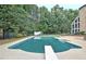 Backyard features a large pool with diving board and surrounding greenery, creating a private outdoor oasis at 104 Hidden Springs Ln, Peachtree City, GA 30269