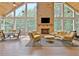 Inviting sunroom featuring vaulted ceiling, brick fireplace and expansive windows showcasing the picturesque outdoors at 104 Hidden Springs Ln, Peachtree City, GA 30269