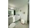 Bright bathroom with double vanity, white cabinetry, decorative artwork and two ottomans at 2757 Malton Way, Loganville, GA 30052