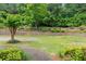 Spacious backyard with lush green grass, mature trees, and a retaining wall, providing a private outdoor oasis at 2855 Middlecreek Way # 2855, Cumming, GA 30041