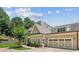 Home features a multi-car garage, stone accents, and manicured landscaping at 2855 Middlecreek Way # 2855, Cumming, GA 30041