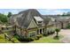 Stunning exterior view of the home showcasing its stone and siding details, complemented by mature landscaping at 2855 Middlecreek Way # 2855, Cumming, GA 30041
