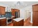 Well-lit kitchen features stainless steel appliances, blue tile backsplash, and island with granite countertop at 2855 Middlecreek Way # 2855, Cumming, GA 30041