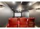 Home theater room featuring tiered seating with red leather chairs and a large projection screen at 2855 Middlecreek Way # 2855, Cumming, GA 30041