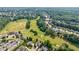 Aerial view showing a golf course and the surrounding neighborhood with lush trees and well-maintained homes at 652 Pathview Ct, Dacula, GA 30019
