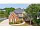 An aerial view of a large brick home next to a lake with professional landscaping and mature trees at 652 Pathview Ct, Dacula, GA 30019