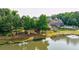 Backyard featuring a pond and beautiful home with an outdoor living space and lush landscaping at 652 Pathview Ct, Dacula, GA 30019