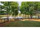 Picturesque backyard featuring a tranquil pond, mature trees, and a fire pit for cozy evenings at 652 Pathview Ct, Dacula, GA 30019