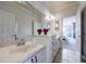 A bright bathroom features a white vanity with red flowers and mirrors, with a door leading to a bedroom at 652 Pathview Ct, Dacula, GA 30019