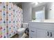 Bathroom with triangle patterned shower curtain, white vanity, large mirror and modern toilet at 652 Pathview Ct, Dacula, GA 30019