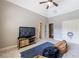Bright bedroom features a ceiling fan, TV on a rustic wood stand, and cozy beanbag chairs on soft carpet at 652 Pathview Ct, Dacula, GA 30019